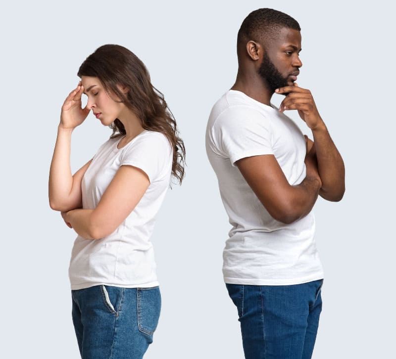 Man and woman standing back to back contemplating and looking defeated