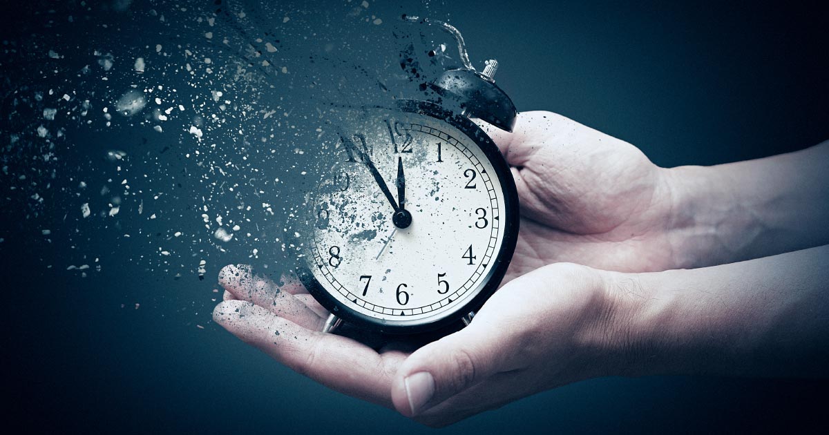 Hand holding a clock that is disappearing