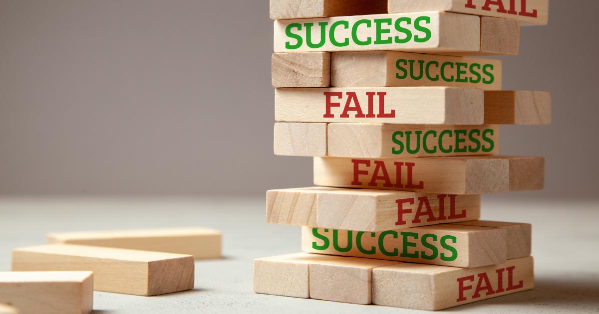 Jenga blocks with the words SUCCESS and FAIL on random pieces